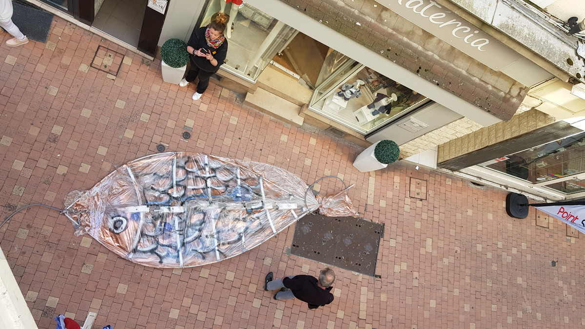 Christophe Alzetto prépare l'installation Cadavre Exquis, à l'aide des ouvriers de la ville et d'une nacelle. On voit l'accrochage en hauteur et ses difficultés