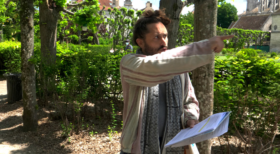 Dans le jardin Bossuet, avec un groupe de visiteurs, Christophe Alzetto joue le guide culturel dans sa performance parodique et réflexive Visite guidée