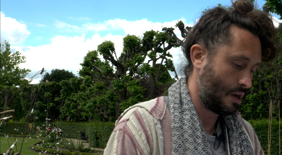 Dans le jardin Bossuet, avec un groupe de visiteurs, Christophe Alzetto joue le guide culturel dans sa performance parodique et réflexive Visite guidée